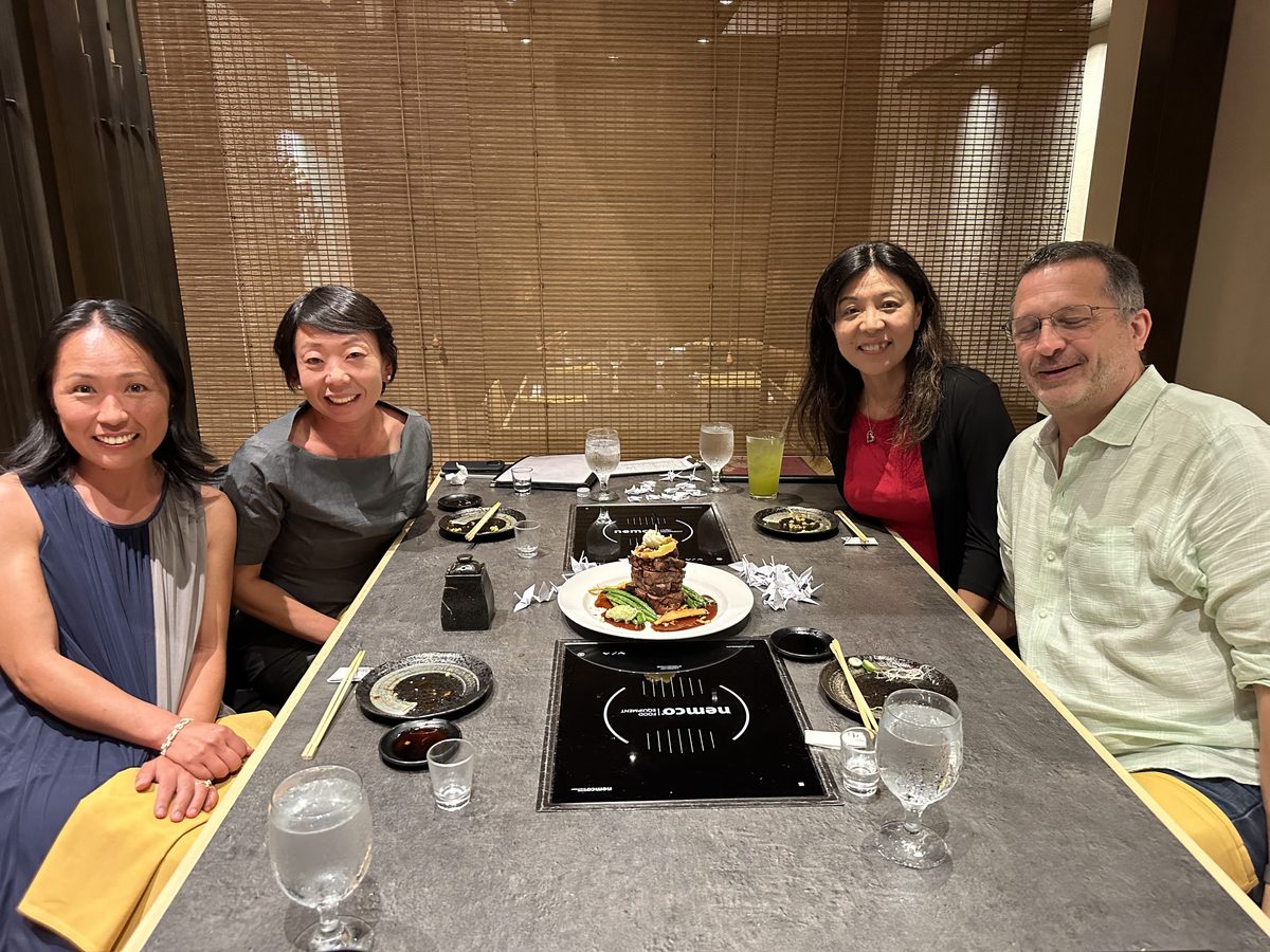 Friends smiling together at the teppanyaki table at Hanagi