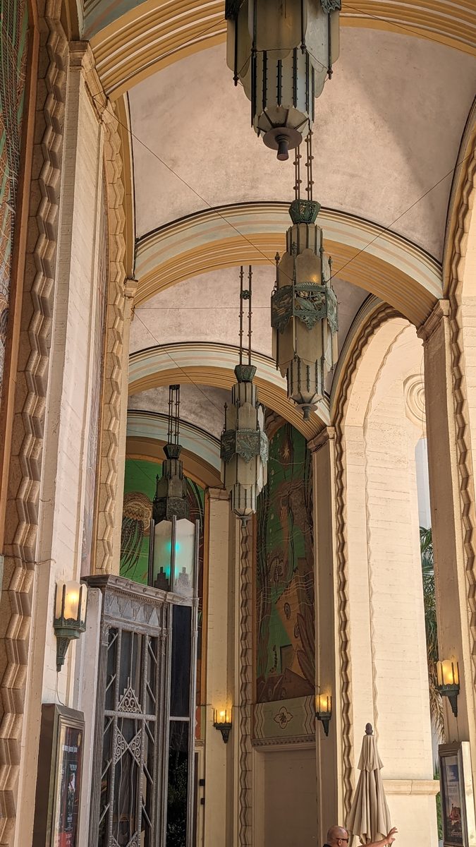 The ornate entrance colonnade of the Avalon Casino — arched ceiling with pendant Art Deco light fixtures and painted murals
