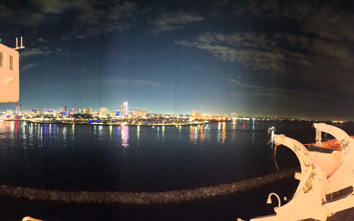 Night panorama from the Queen Mary's bow deck — Long Beach city lights reflected in the harbor water
