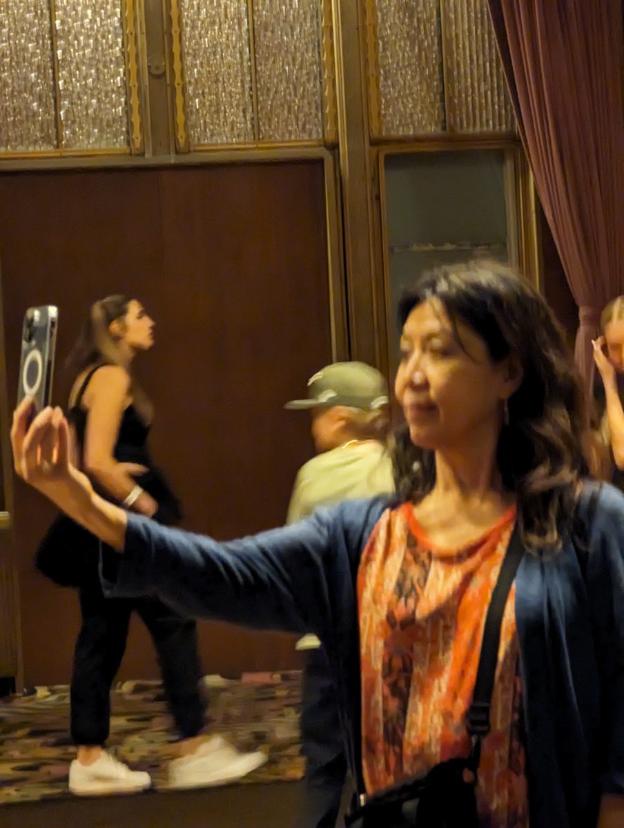 Ako taking a selfie in one of the Queen Mary's ornate Art Deco salons, with dark wood paneling and etched glass panels
