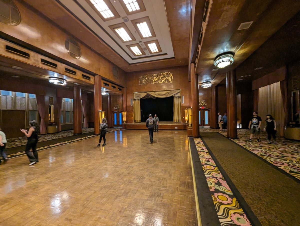 The Grand Salon ballroom of the Queen Mary — a vast Art Deco space with parquet floor and a gold-curtained stage