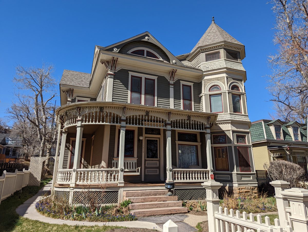 The full Queen Anne Victorian exterior of the McAllister House with its turret and wraparound porch