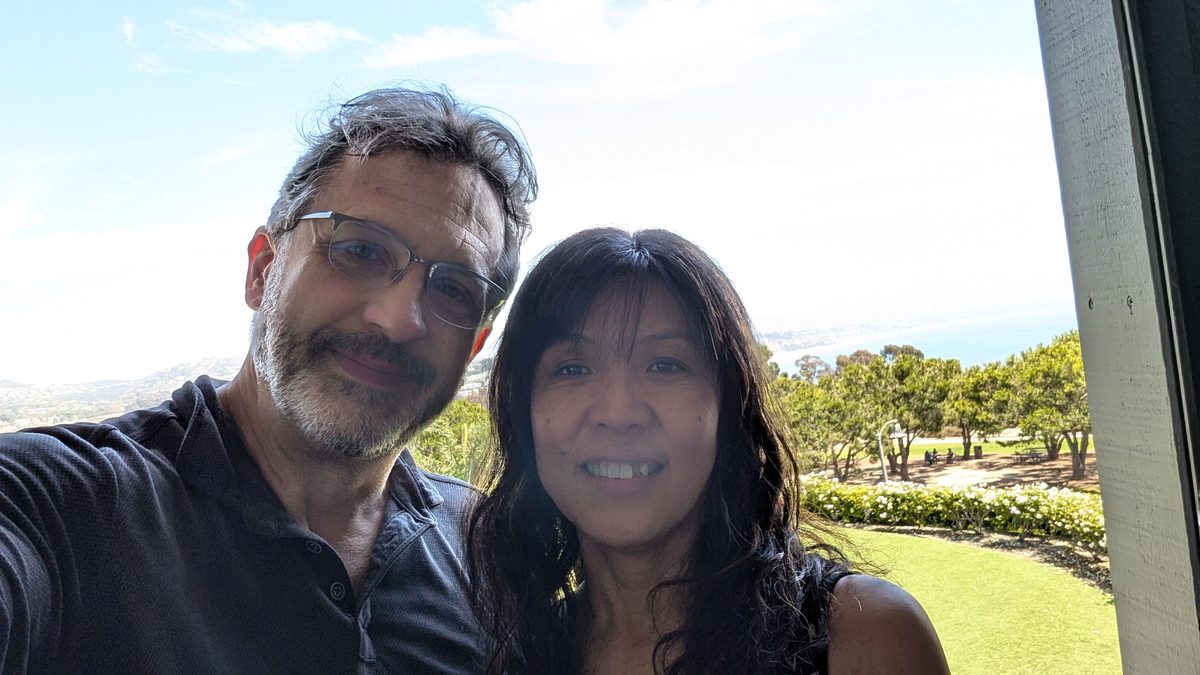 Eddy and Ako in a sunny selfie at the Laguna Cliffs, the Pacific behind them — Honeymoon 2024