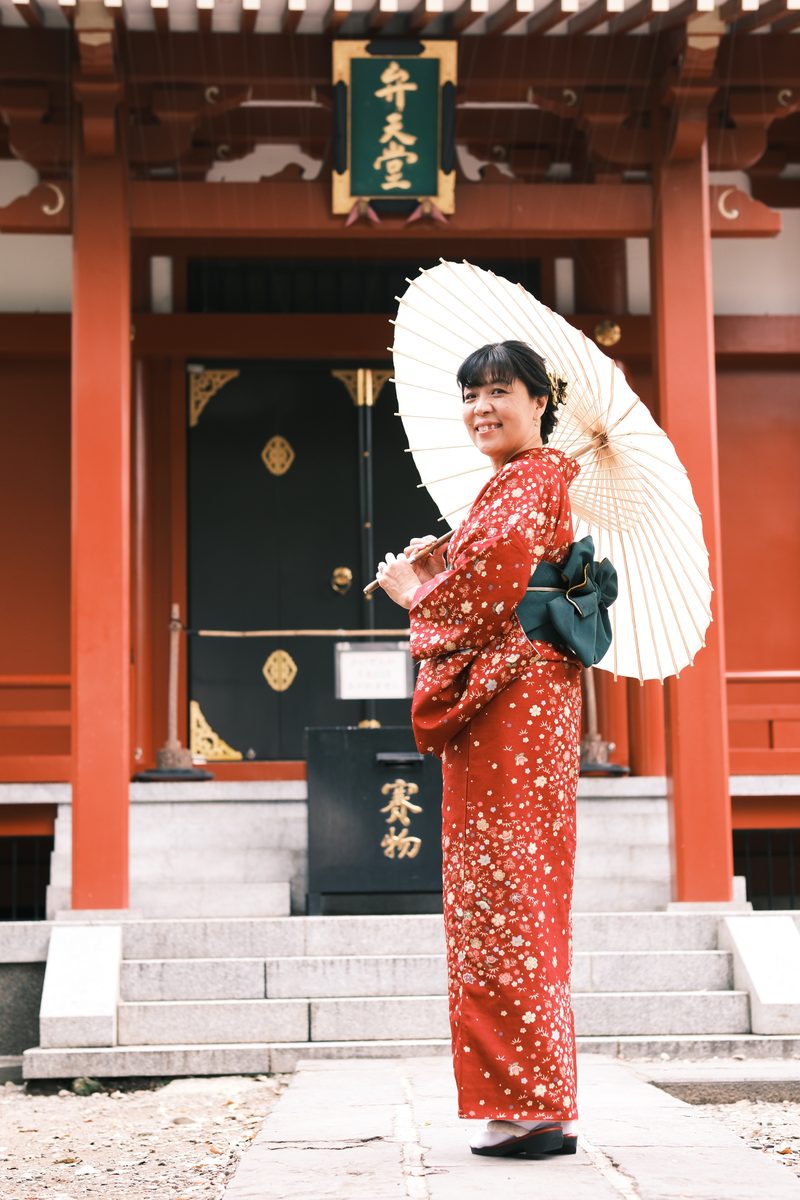 Ako alone at the Sensoji gate, holding the wagasa, looking upward at the temple structure