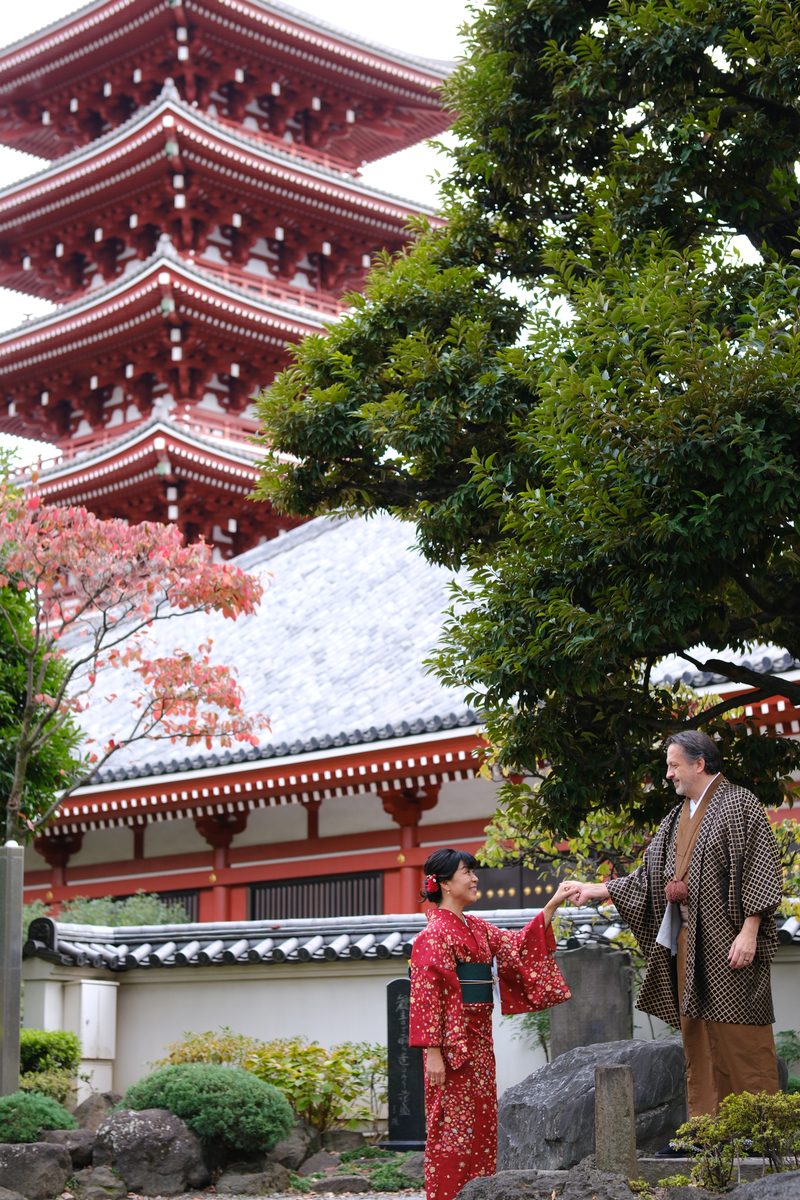 Wide shot with the Sensoji pagoda prominent, Eddy and Ako in the foreground amid autumn foliage