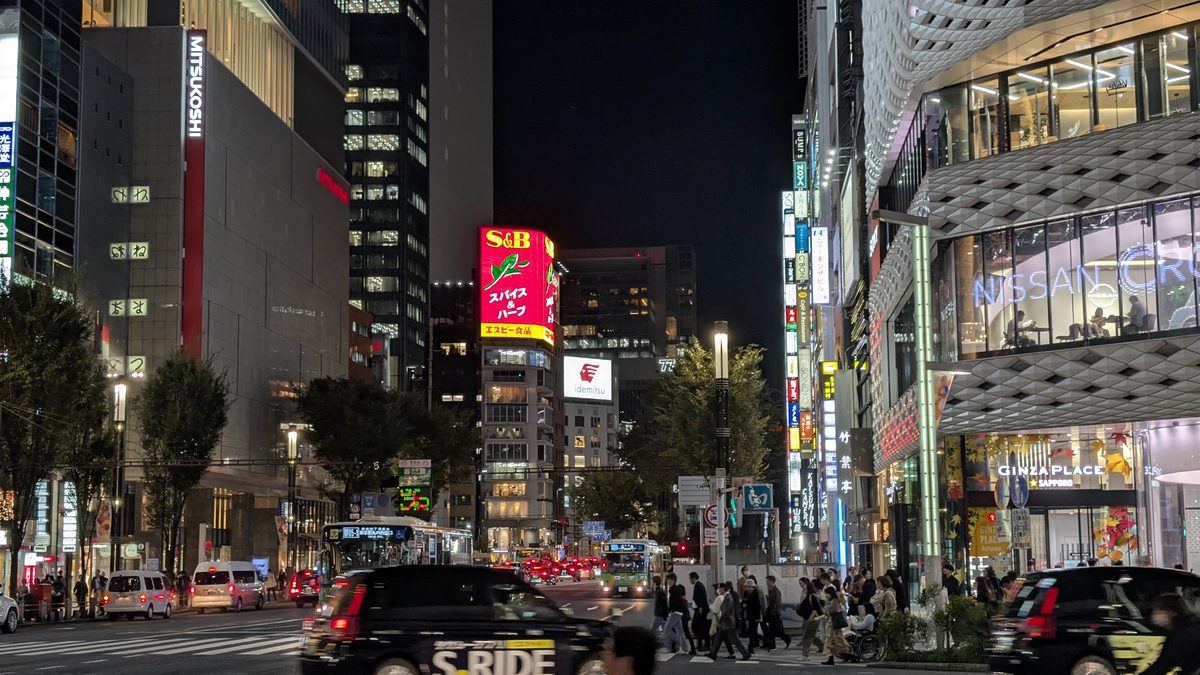 Night street scene at the Ginza Place crossing with neon and traffic