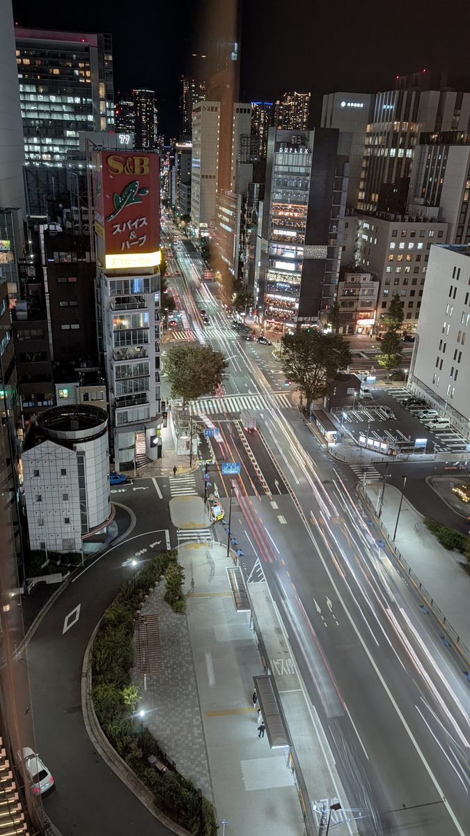 Long-exposure night view down a Ginza avenue with car light trails