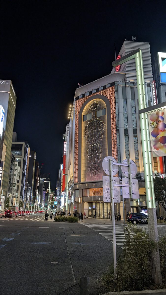A brightly illuminated building facade over an empty Ginza crossing at night