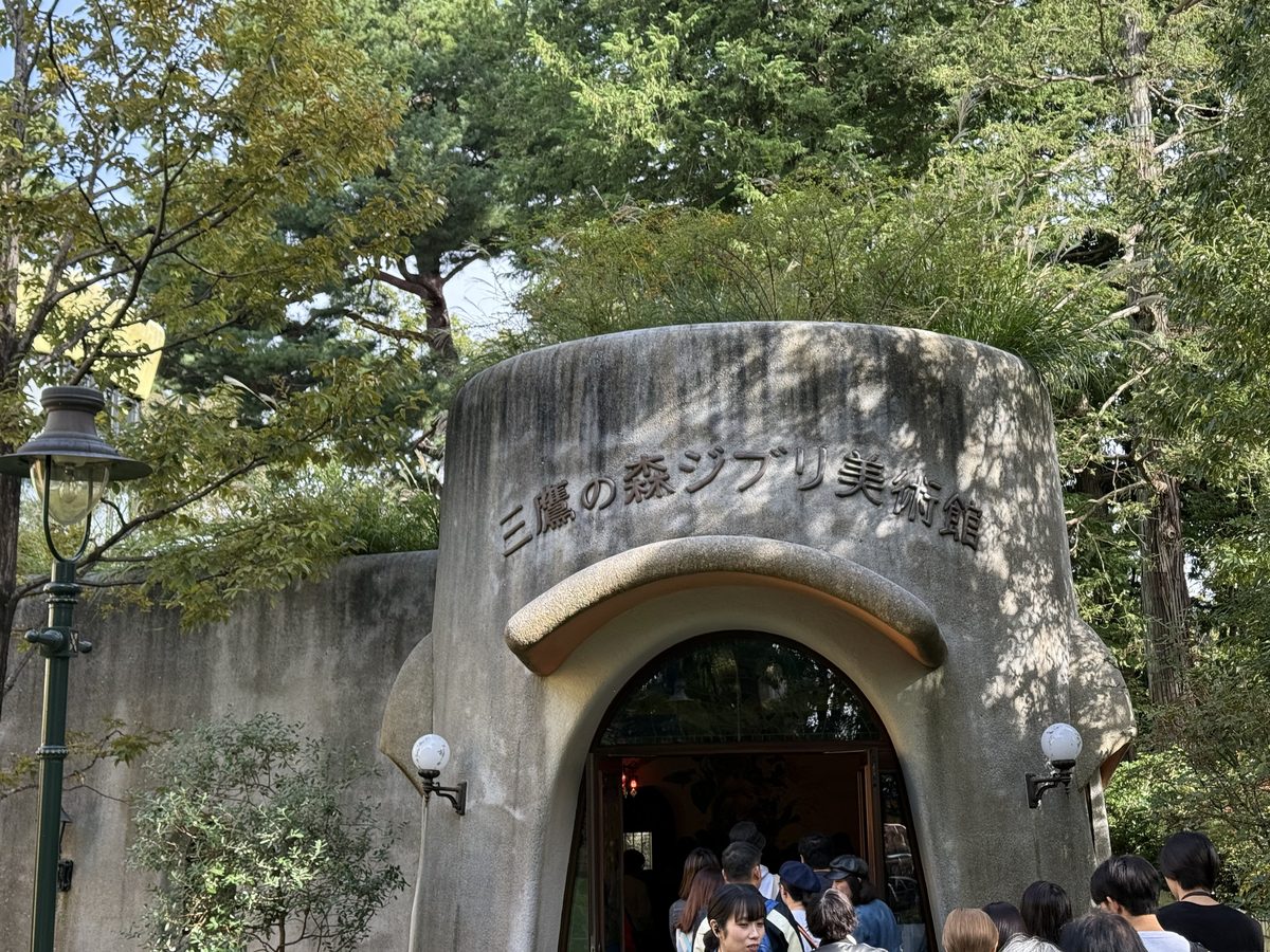 The rounded concrete storybook entrance of the Ghibli Museum with people queuing