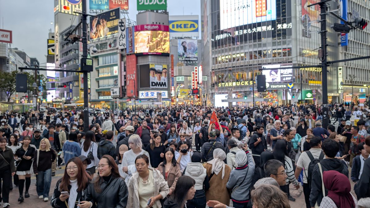 The Shibuya Scramble Crossing packed with crowds beneath giant billboards