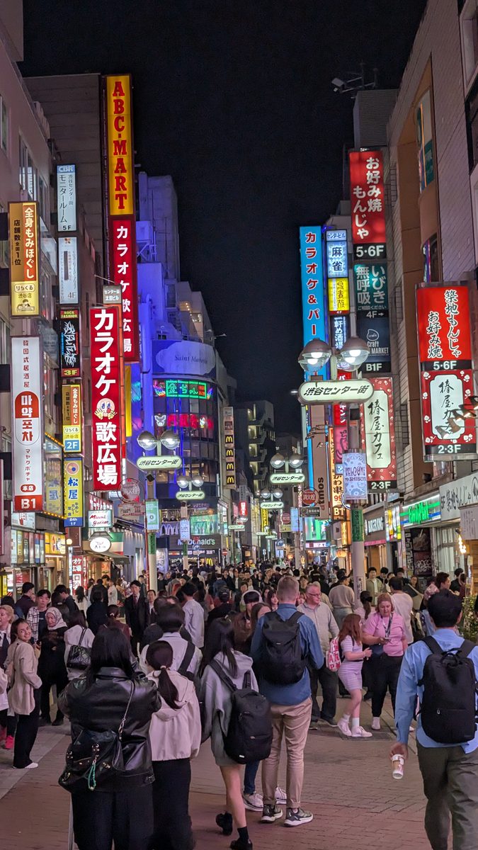 Shibuya Center-Gai at night, crowds beneath stacked neon signs