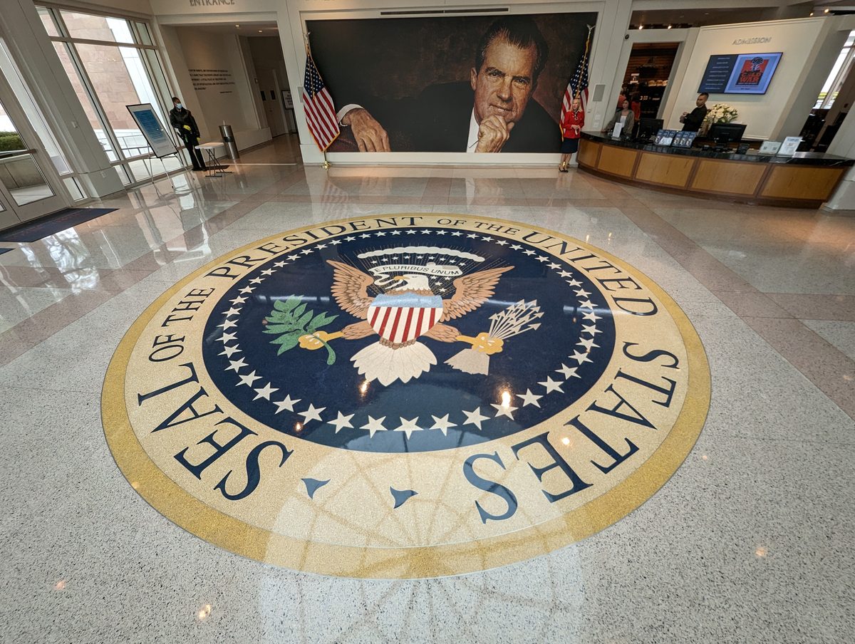 The museum lobby with the Presidential Seal inlaid in the floor and a large portrait of Nixon on the wall