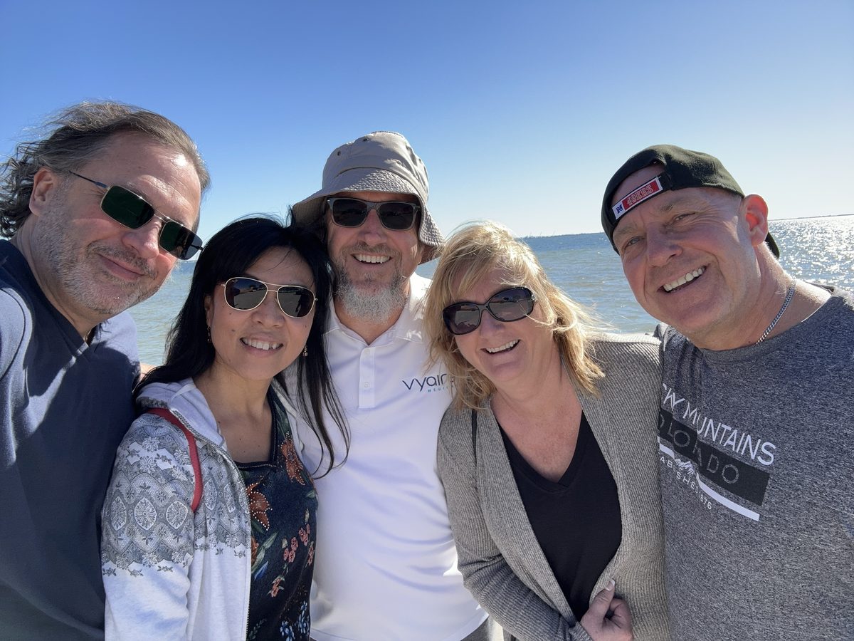 A sunny group selfie of Eddy, Ako and three friends in sunglasses by the water